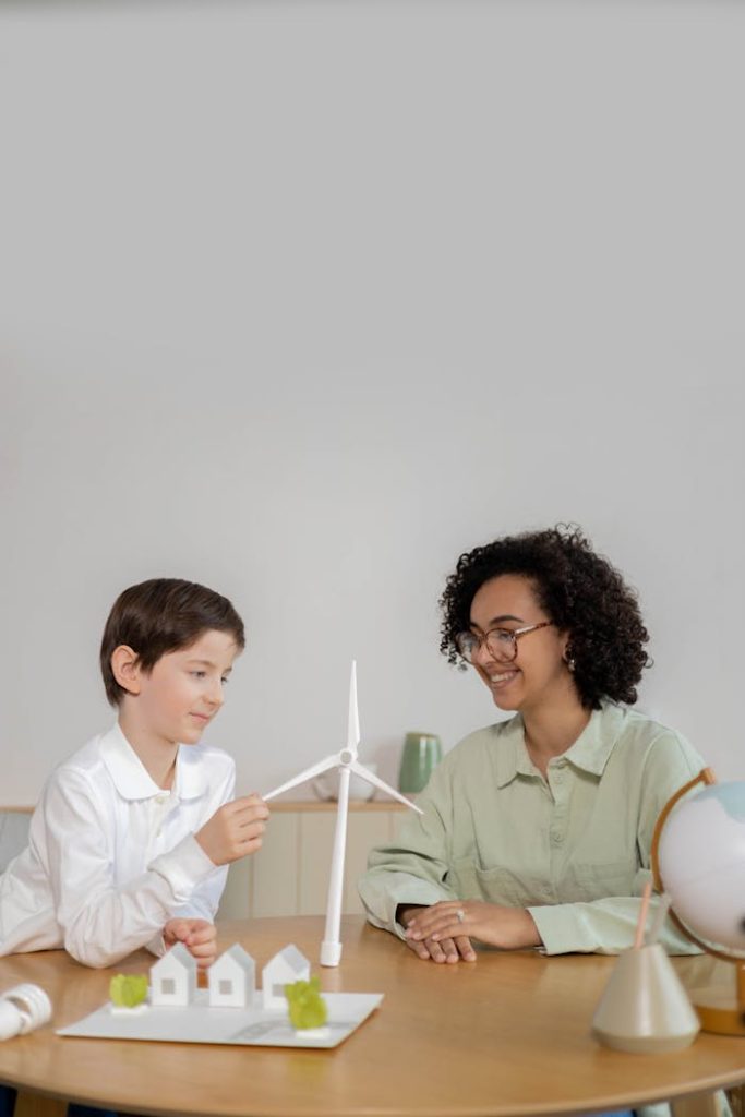 man-person-construction-desk-6991094 Child and teacher exploring wind energy with turbine model in classroom.